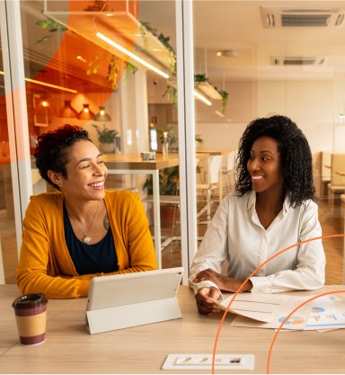 imagem de duas mulheres em um escritório dando risadas