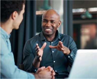 Imagem de dois homens conversando dentro de um escritório